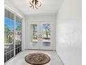 Bright foyer with tile flooring, double doors, and large window at 7779 Holiday N Dr, Sarasota, FL 34231
