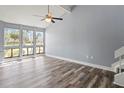 Bright living room featuring gray walls, vaulted ceiling with fan, wide windows and modern gray flooring at 800 S Blvd Of The Presidents # 5, Sarasota, FL 34236