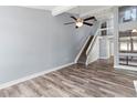 Open living room showcasing gray walls, a ceiling fan, stairs to the upper level and wood-look flooring at 800 S Blvd Of The Presidents # 5, Sarasota, FL 34236