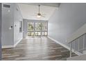 Light-filled living room with gray walls, vaulted ceiling, ceiling fan and large windows offering a pleasant view at 800 S Blvd Of The Presidents # 5, Sarasota, FL 34236