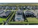 Aerial view of home with a screened-in pool area and meticulously maintained backyard at 8273 Shooting Star Rd, Sarasota, FL 34241