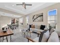 Sunlit living room featuring a cozy sofa, stylish decor, and large windows that provide ample natural light at 8273 Shooting Star Rd, Sarasota, FL 34241