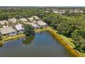 Aerial view of home with screened-in patio overlooking lake surrounded by lush green trees at 8525 54Th Avenue E Cir, Bradenton, FL 34211
