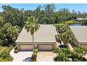 Aerial view of home with lush tropical landscaping, tile roof, and brick driveway at 8525 54Th Avenue E Cir, Bradenton, FL 34211