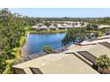 Aerial view of community homes surrounding a serene lake with mature trees and lush landscaping at 8525 54Th Avenue E Cir, Bradenton, FL 34211