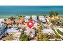 Beach house located near white sandy beaches and turquoise waters, surrounded by lush palm trees and beautiful scenery at 880 N Shore Dr, Anna Maria, FL 34216