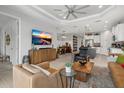 Open-concept living room showcasing stylish furnishings, a modern TV, and seamless transition to the dining and kitchen areas at 10120 Canaveral Cir, Sarasota, FL 34241