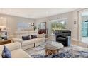 Spacious living room includes hardwood floors, modern furniture, sliding glass doors, and a view of the screened lanai at 10186 Crystal Isle Cir, Sarasota, FL 34241