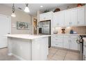 Bright kitchen boasts stainless steel appliances, white cabinetry, and a large island with sink at 11435 Fort Lauderdale Pl, Venice, FL 34293