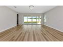 Bright living room featuring wood flooring, a modern chandelier, and sliding glass doors to the backyard at 12613 Oak Hill Way, Parrish, FL 34219