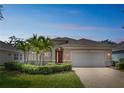 Charming single-story home with a two-car garage, manicured landscaping, and beautiful palm trees at 12642 Cara Cara Loop, Bradenton, FL 34212