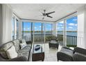 Bright sun room with serene water view, comfortable seating, and tile flooring at 1280 Dolphin Bay Way # 204, Sarasota, FL 34242