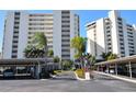 Condo building exterior with carport and tropical landscaping at 19 Whispering Sands Dr # 805, Sarasota, FL 34242