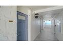 Condo hallway leading to unit 805 with textured walls and tile flooring overlooking water views at 19 Whispering Sands Dr # 805, Sarasota, FL 34242