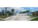 Wide angle of light blue single-story home, blue cottage, white fence, and xeriscaped yard at 21403 Glendale Ave, Port Charlotte, FL 33952