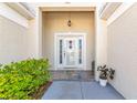 Inviting home entrance with decorative details, lush greenery and warm lighting at 230 Fareham Dr, Venice, FL 34293