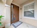 Front door with sidelight and stylish hardware, and an elegant outdoor light fixture at 23233 Banbury Way # 302, Venice, FL 34293