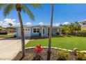 Charming coastal home featuring a well-manicured lawn, garage, screened porch, and lush tropical landscaping at 237 85Th St, Holmes Beach, FL 34217