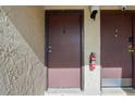 Close-up of apartment entrances featuring dark doors, security features, and a fire extinguisher at 2704 Hidden Lake Blvd # C, Sarasota, FL 34237