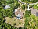 Aerial view of a backyard with a screened-in pool surrounded by lush greenery at 296 Pine Ranch Trl, Osprey, FL 34229