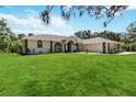 Charming single-story home with a lush green lawn and eye-catching architectural details at 296 Pine Ranch Trl, Osprey, FL 34229
