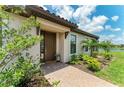 Inviting front entrance with brick walkway and blooming foliage in the landscaped garden at 3027 Formia Ct, Lakewood Ranch, FL 34211