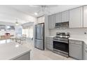 Bright, updated kitchen featuring stainless steel appliances and gray cabinets with modern lighting at 3978 Overlook Bend Ter # 25, Sarasota, FL 34232