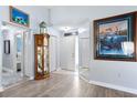 Inviting foyer with light wood-look flooring, a mirror, and decorative art pieces at 4203 Carriage Dr # 27, Sarasota, FL 34241