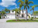 Beautiful two-story home boasting mature palms, lush landscaping, and a paver driveway leading to a two-car garage at 430 Pheasant Way, Sarasota, FL 34236
