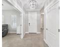 Bright foyer with tiled floor, chandelier, and white front door at 4406 Rustling Pines Ter, Parrish, FL 34219