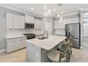 Modern kitchen featuring stainless steel appliances, a center island with seating, and sleek countertops at 4406 Rustling Pines Ter, Parrish, FL 34219