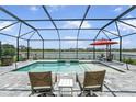 Inviting screened-in pool area with lake views, lounge chairs, and ample space for relaxation and outdoor living at 4406 Rustling Pines Ter, Parrish, FL 34219