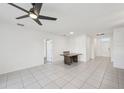 Spacious living room with neutral tile flooring, fan, and access to other areas of the home at 4503 Lindever Ln, Palmetto, FL 34221