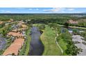 Expansive aerial view showcasing the community, golf course, and water features surrounded by trees at 4505 Kingsmere # 2, Sarasota, FL 34235