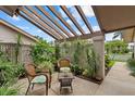 Cozy outdoor patio with comfortable seating, lush greenery, and a pergola shading at 4505 Kingsmere # 2, Sarasota, FL 34235