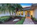 Stunning entrance to the home, surrounded by tropical landscaping and a stone walkway at 4665 Pine Harrier Dr, Sarasota, FL 34231