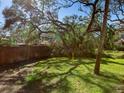 Shady backyard featuring green grass and a wooden fence at 4869 Village Gardens Dr # 189, Sarasota, FL 34234