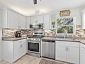 Updated kitchen with white cabinets, stainless steel appliances, and mosaic backsplash at 4869 Village Gardens Dr # 189, Sarasota, FL 34234