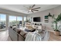 Bright living room features modern ceiling fan, plush grey sofa, and sliding glass doors to a balcony at 501 Haben Blvd # 506, Palmetto, FL 34221