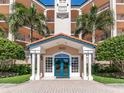 Detailed view of the condo's entrance with stately columns and manicured greenery at 5420 Eagles Point Cir # 106, Sarasota, FL 34231