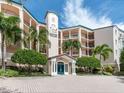 Stunning condo entrance featuring a porte cochere, blue doors, and well-maintained landscaping at 5420 Eagles Point Cir # 106, Sarasota, FL 34231