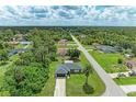 An aerial view showcases the home's location within a lush, green neighborhood and long driveway at 5482 Globe Ter, North Port, FL 34286