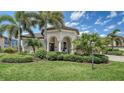 Beautifully landscaped front yard with mature palm trees and manicured bushes, offering curb appeal at 5622 Arnie Loop, Lakewood Ranch, FL 34211