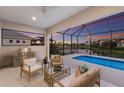 Covered patio with comfortable seating, outdoor kitchen, and a stunning view of the pool and pond at 5718 Title Row Dr, Bradenton, FL 34210
