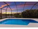 Inviting screened-in pool with stunning sunset views over the lake and neighboring homes at 5718 Title Row Dr, Bradenton, FL 34210