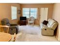 Comfortable living room with cozy seating, neutral carpet, and natural light from the windows at 6110 Coral Way, Bradenton, FL 34207