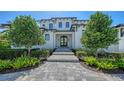 Elegant home entrance with a stone walkway and well-maintained landscaping at 612 Mourning Dove Dr, Sarasota, FL 34236