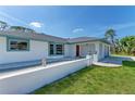 Well-kept single-story home with a stylish red door, blue trim, and attached garage at 645 Liberty St, Englewood, FL 34223