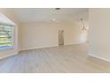 Open-concept living area with light wood-look flooring and neutral wall colors at 645 Liberty St, Englewood, FL 34223