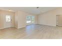 Bright living room with light wood-look flooring and bay window for natural light at 645 Liberty St, Englewood, FL 34223